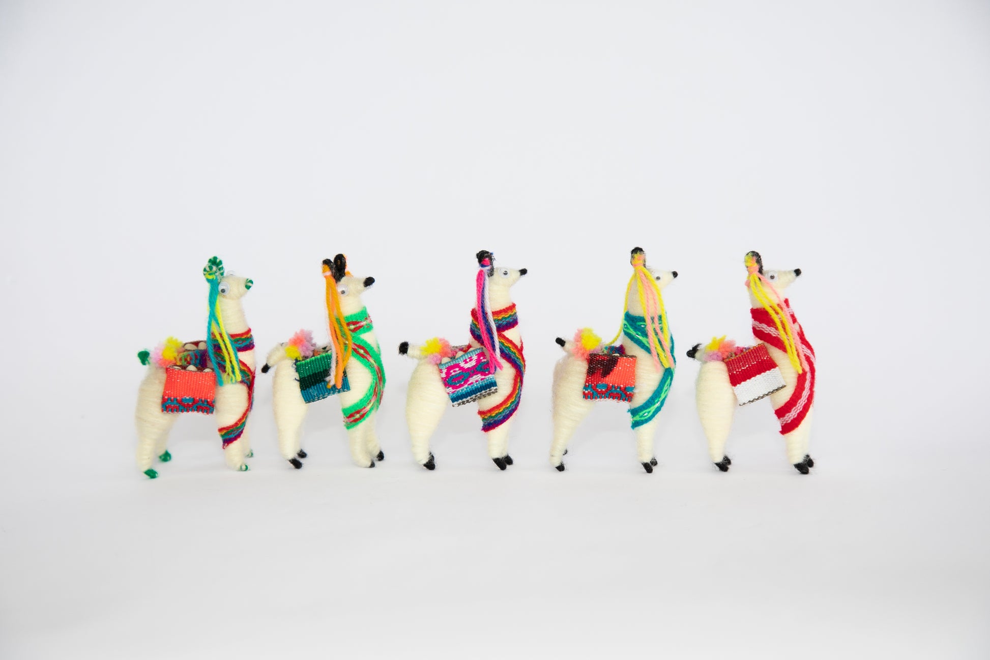 Small Llama Figurines Standing in Line Facing Right